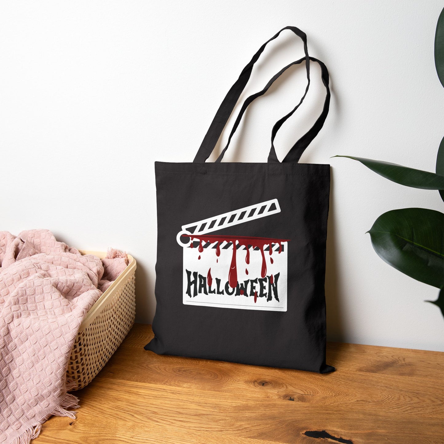 Black tote bag with Halloween design on a wooden surface