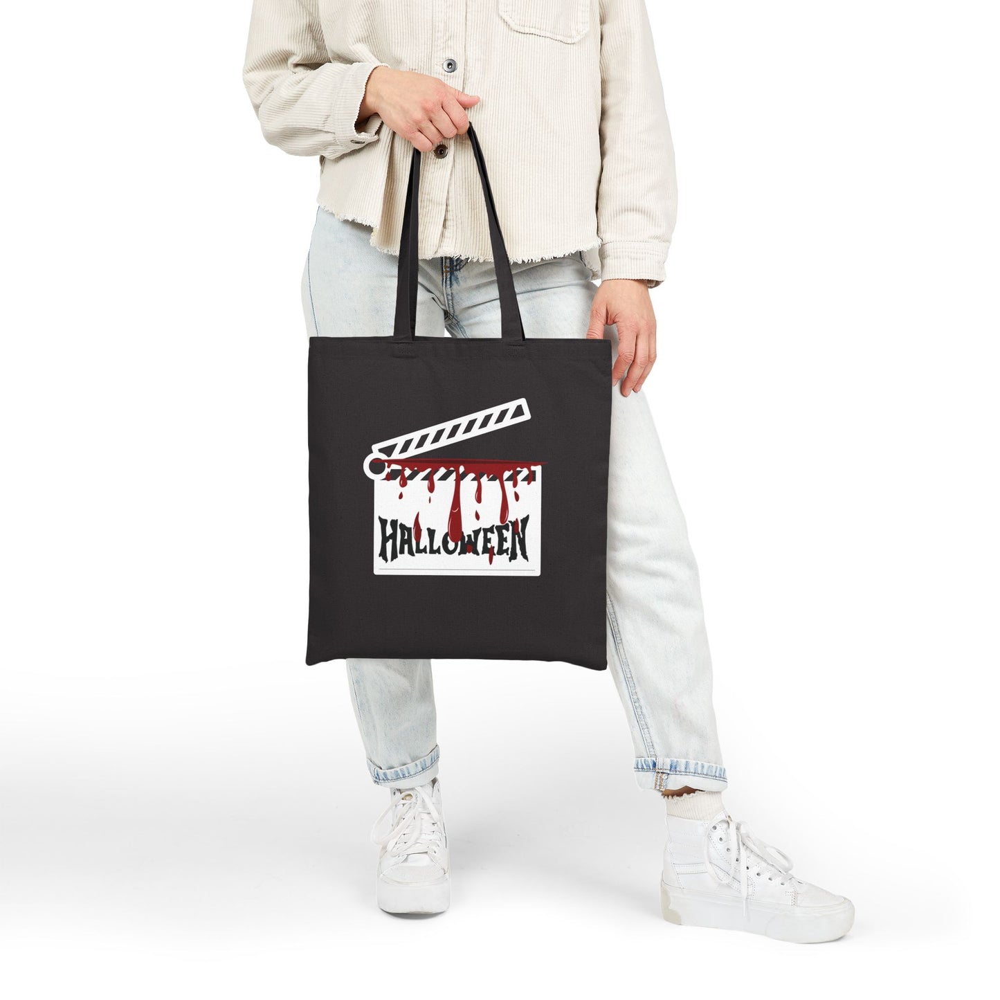 Person carring a black tote bag with 'Halloween' design on a white background