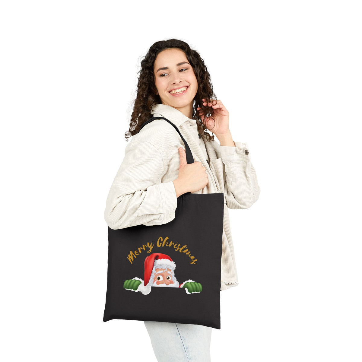 Woman wearing a black cotton tote bag printed with a cute Santa Claus graphic and Merry Christmas text for casual holiday fashion.
