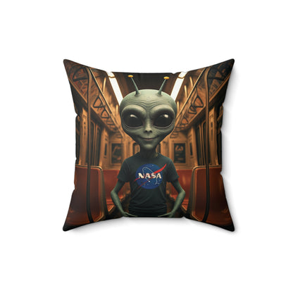 A grey alien wearing a NASA t-shirt sitting on a New York City subway train.