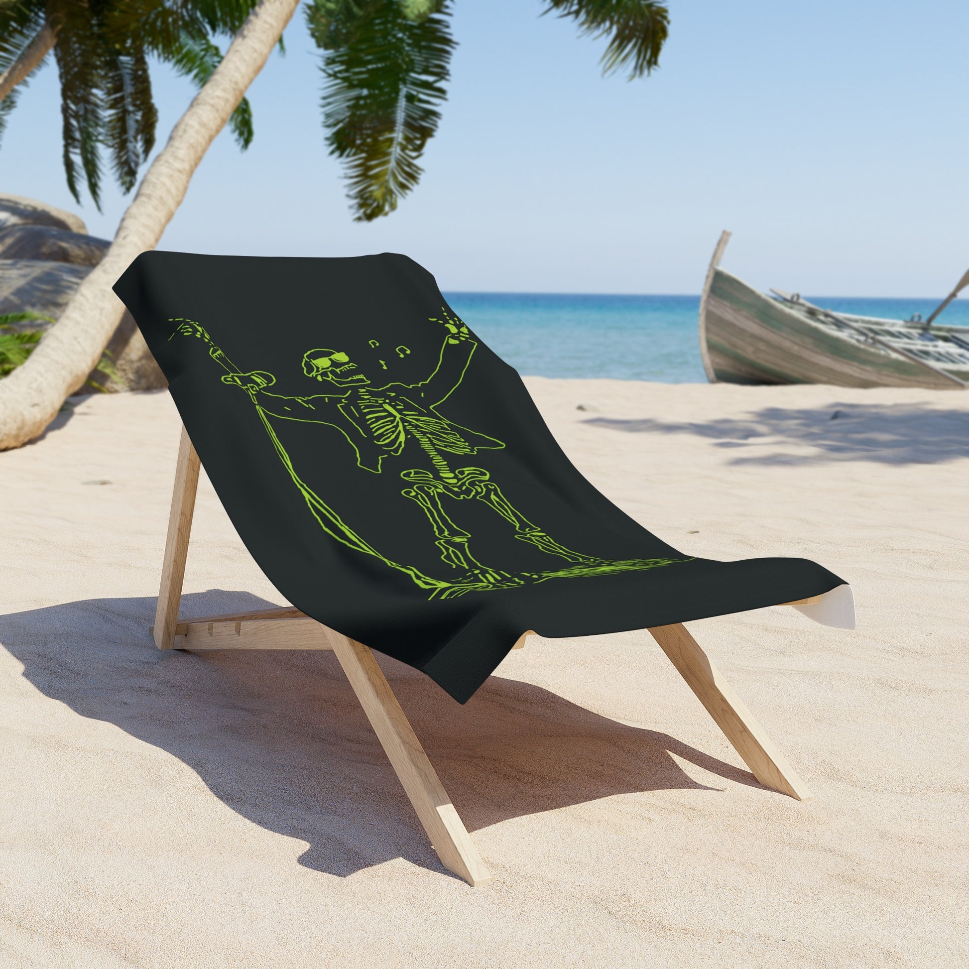 Black towel with green skeleton design on a beach chair at the beach