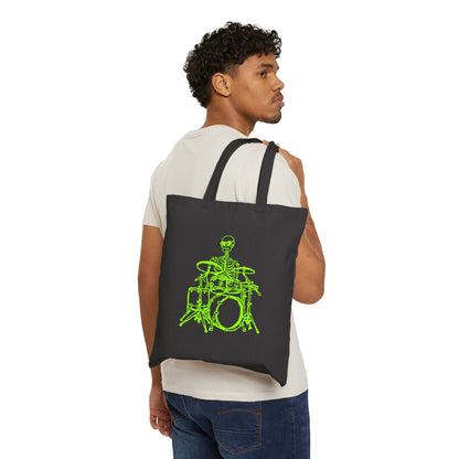 Person carrying a black tote bag with a original green skeleton playing drums