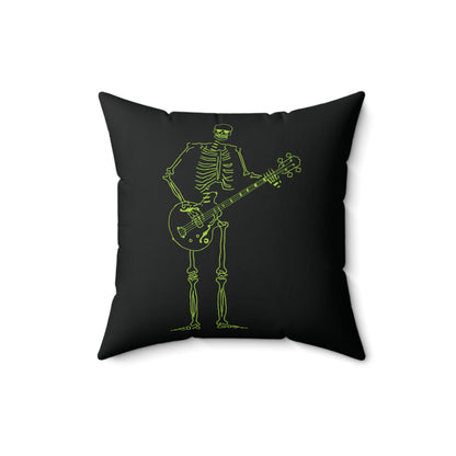Fluorescent green skeleton playing a bass guitar on a decorative pillow.