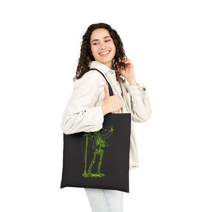 Woman holding a black tote bag with a green skeleton design on a white background