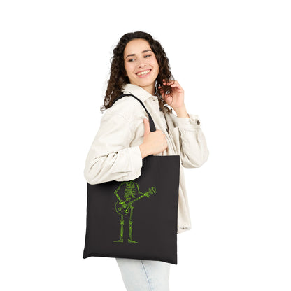 Woman holding a black tote bag with a green skeleton design on a white background