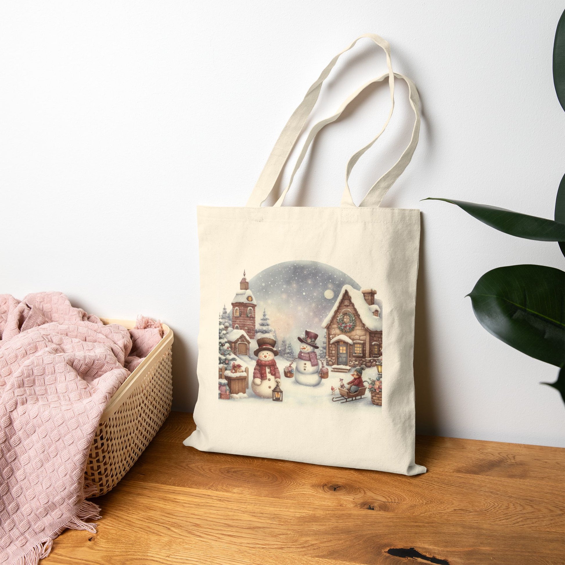 Winter scene design featuring snowmen and a house, placed on a Natural Canvas tote bag. Unique and originalc Christmas design.