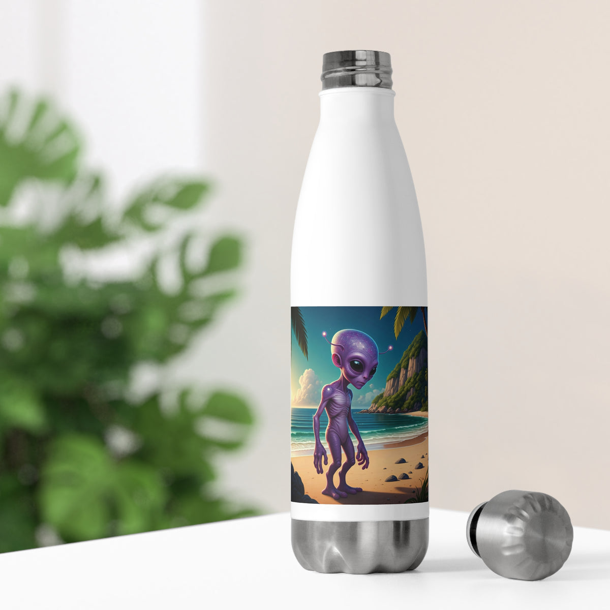 White thermal water bottle sitting on a bright desk with its stainless steel cap off, showing colorful alien artwork for home office hydration.