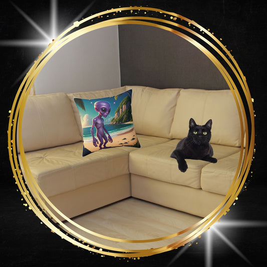 Decorative throw pillow featuring an alien on a tropical beach graphic from From Space Store on a beige sofa next to a black cat.