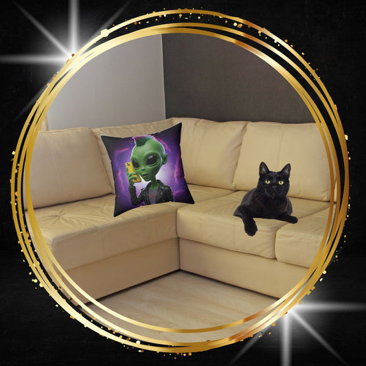 Decorative throw pillow featuring an alien wearing a leather jacket and using a phone graphic from From Space Store on a beige sofa next to a black cat.