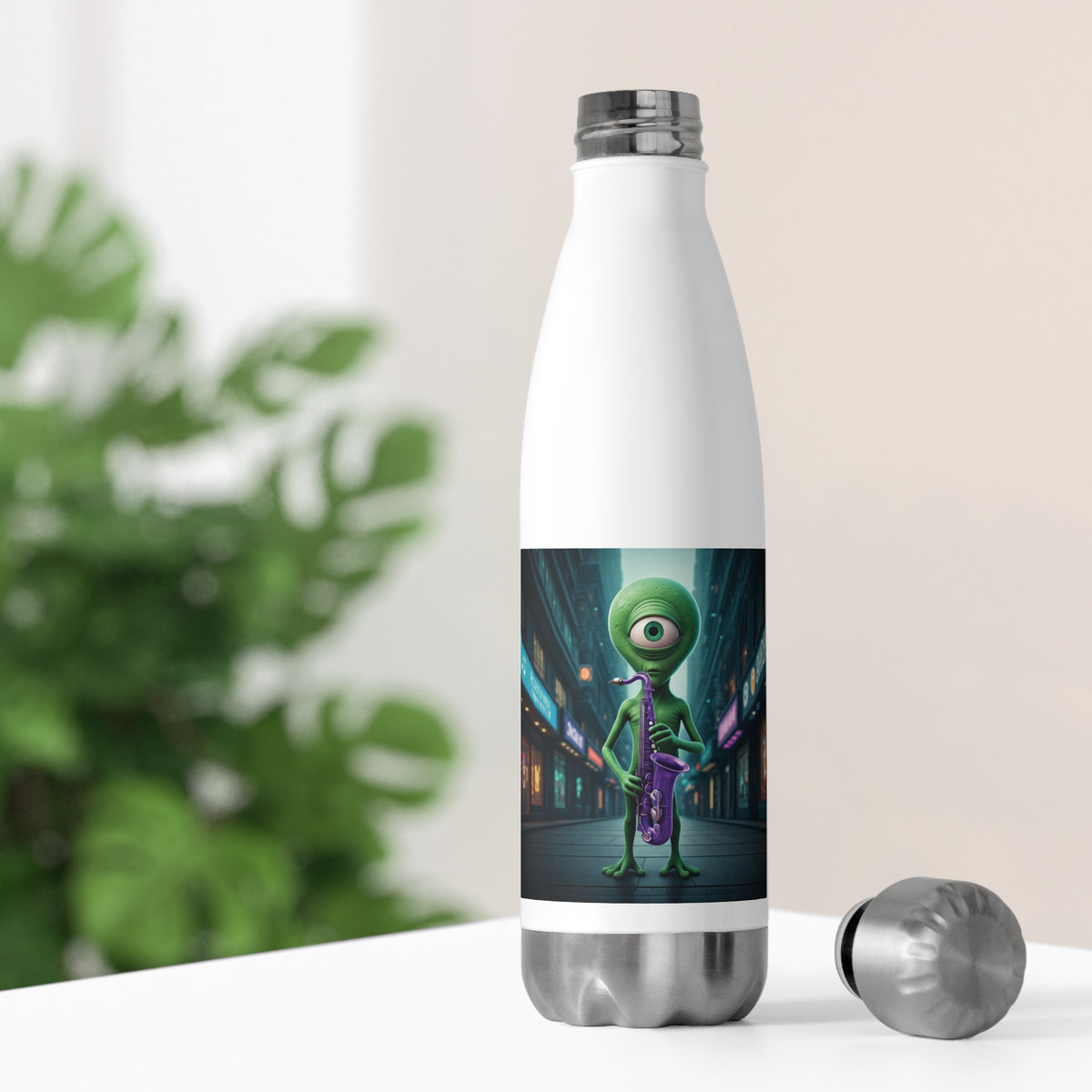 White thermal music water bottle on a bright desk with its silver stainless steel cap off, showing a cosmic saxophone alien design for office hydration.