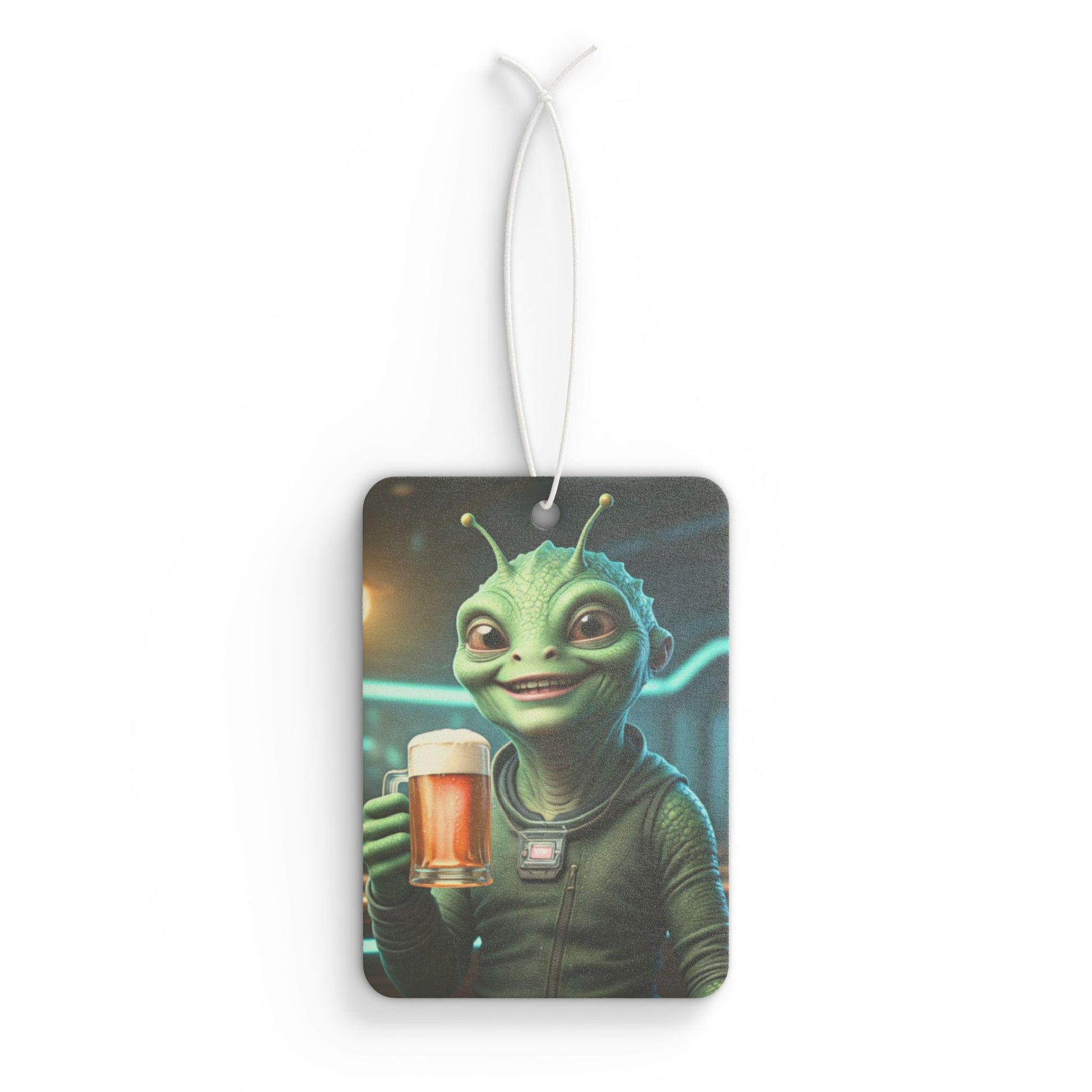 Rectangular car air freshener showing a green alien smiling and holding up a glass mug of foamy craft beer against a neon background.