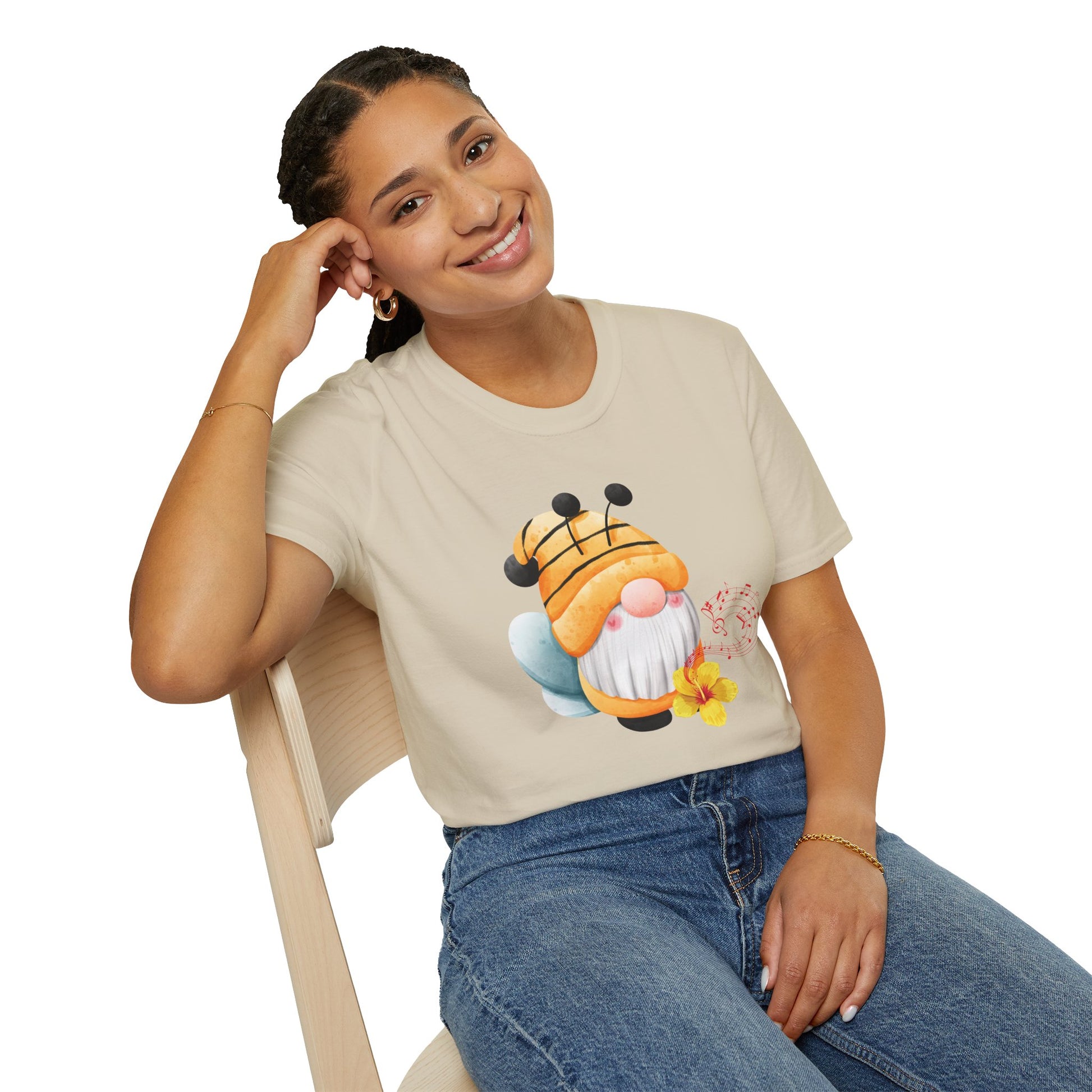 A woman wearing a beige graphic t-shirt with a cartoon bee gnome design.