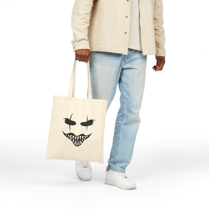Person holding a tote bag with a face design on a white background
