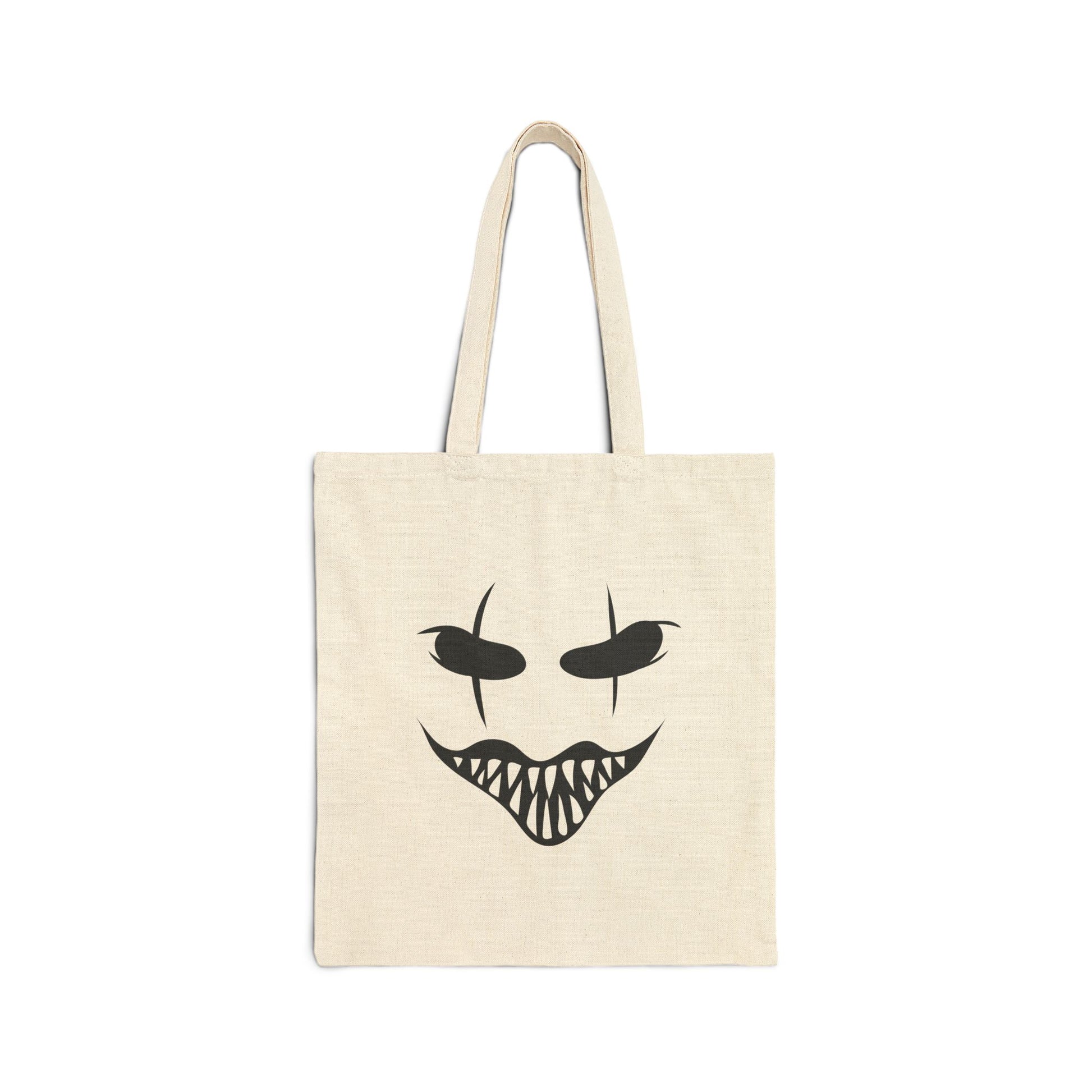 Beige tote bag with a black face design on a white background