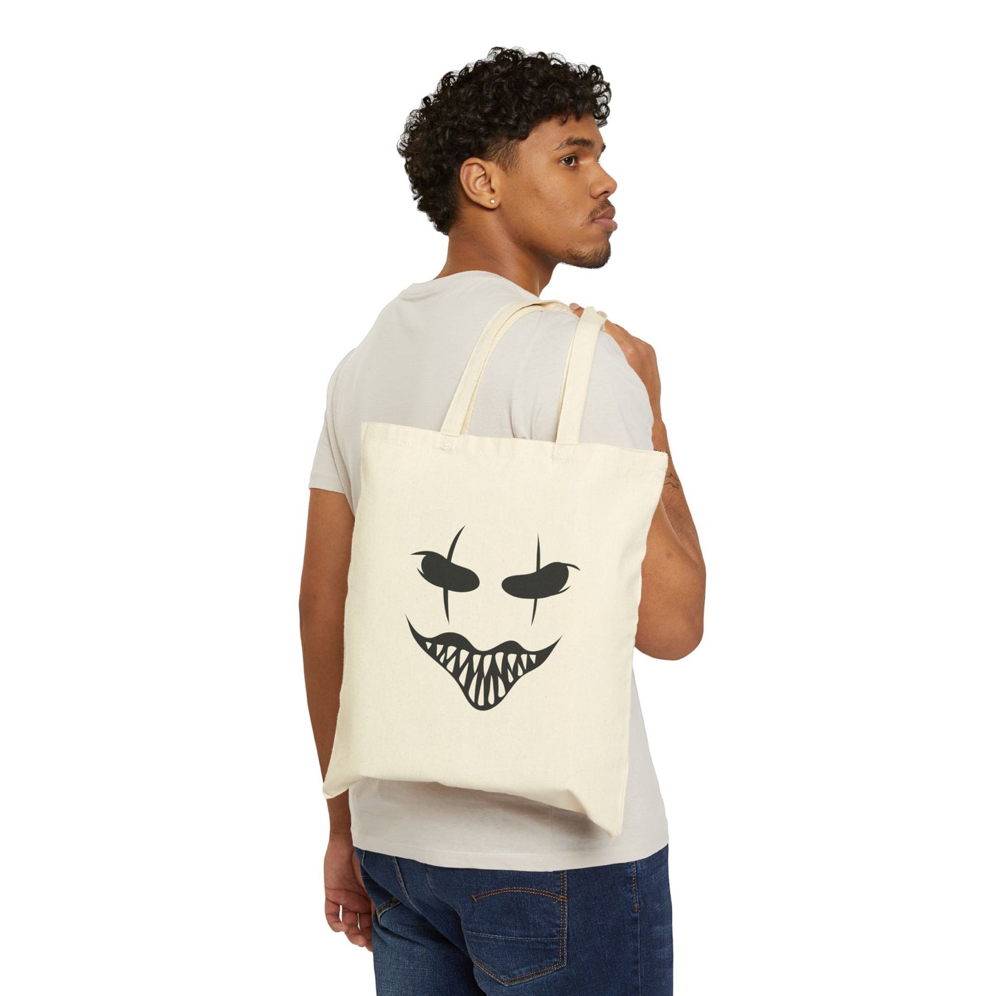 Man holding a tote bag with a face design on a white background
