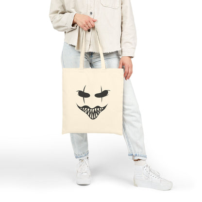 Person holding a halloween Mask tote bag with a face design on beige space