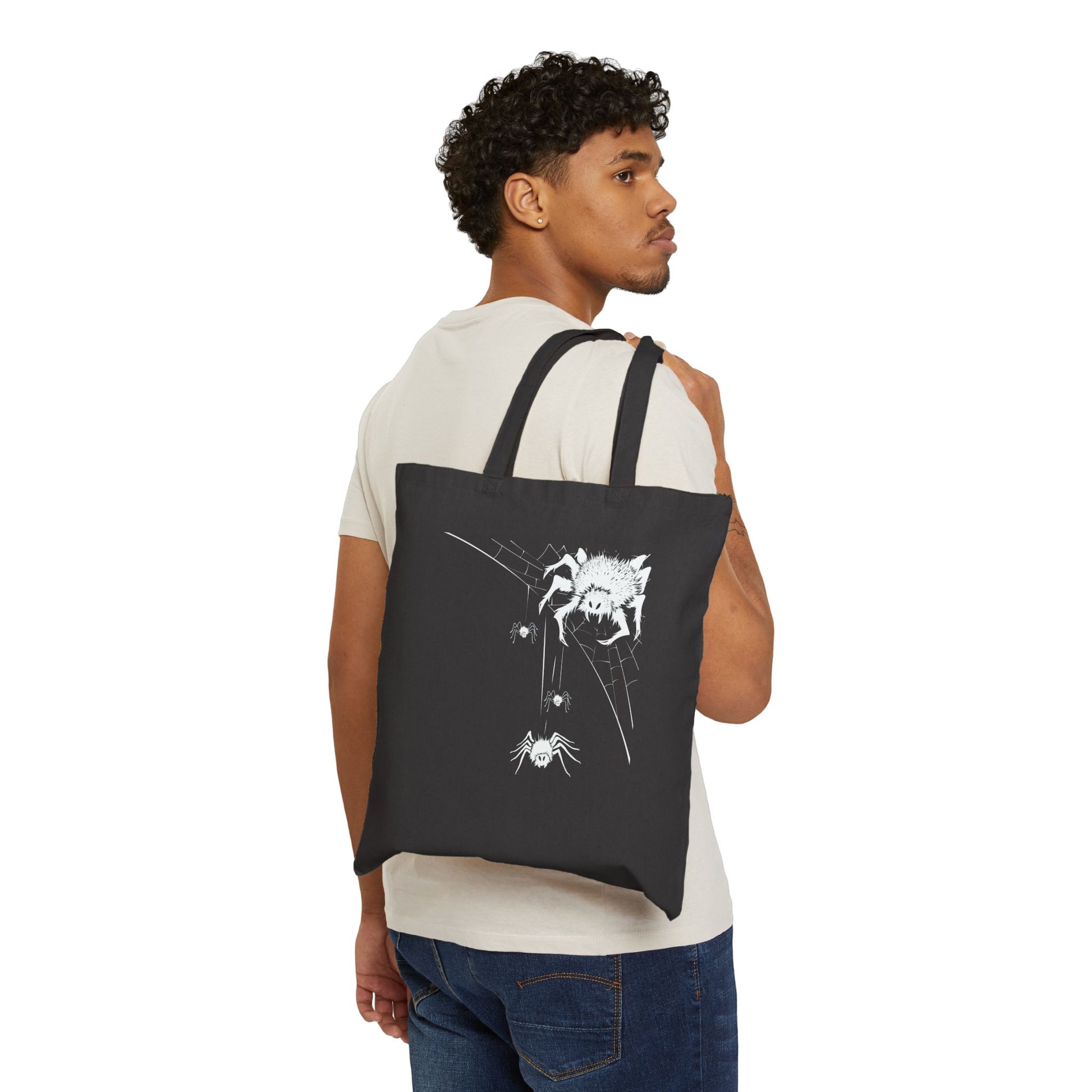 Man carrying a black tote bag with a soider unique graphic design
