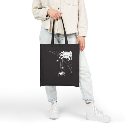 Young woman holding a unique black tote bag with a white original spider design, halloween vibes
