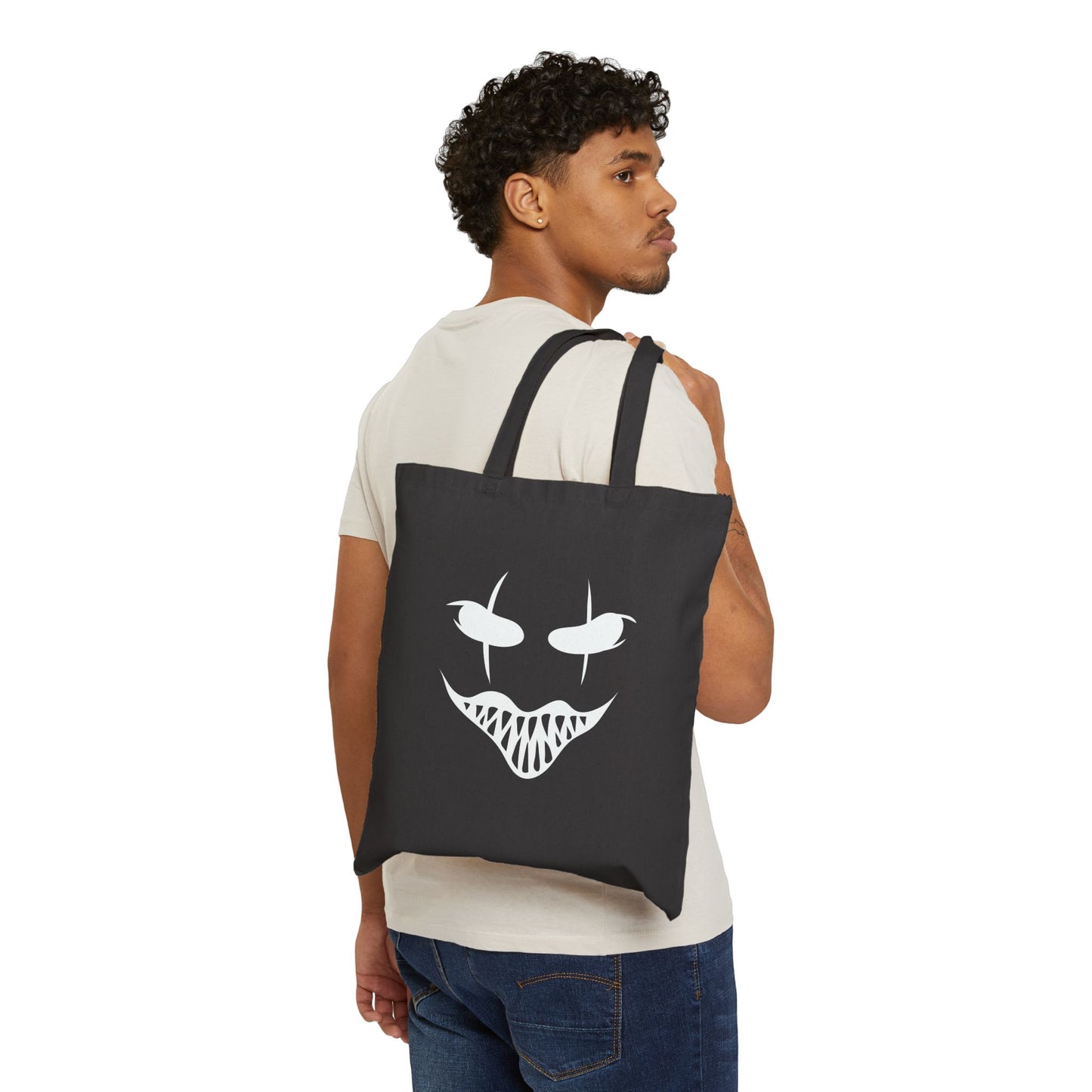Person wearing a black tote bag with a white face design on a white background