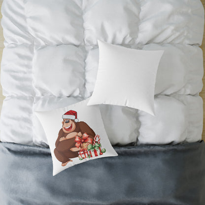 White pillow with a cartoon bear design on a bed with white bedding and gray blanket.
