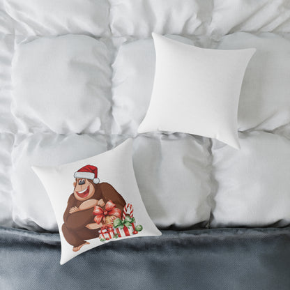 Decorative pillow with a bear wearing a Santa hat and holding a gift on a bed with white pillows.