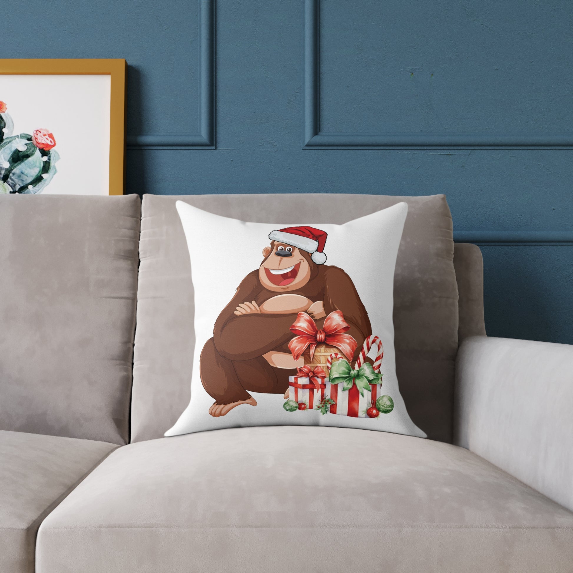 Decorative pillow with a cartoon bear wearing a Santa hat on a gray sofa against a blue wall.