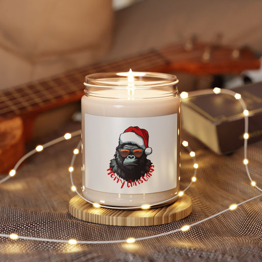 Lit soy wax glass jar Christmas candle featuring a cool gorilla wearing sunglasses and a Santa hat with Merry Christmas text, glowing with warm fairy lights on a table.