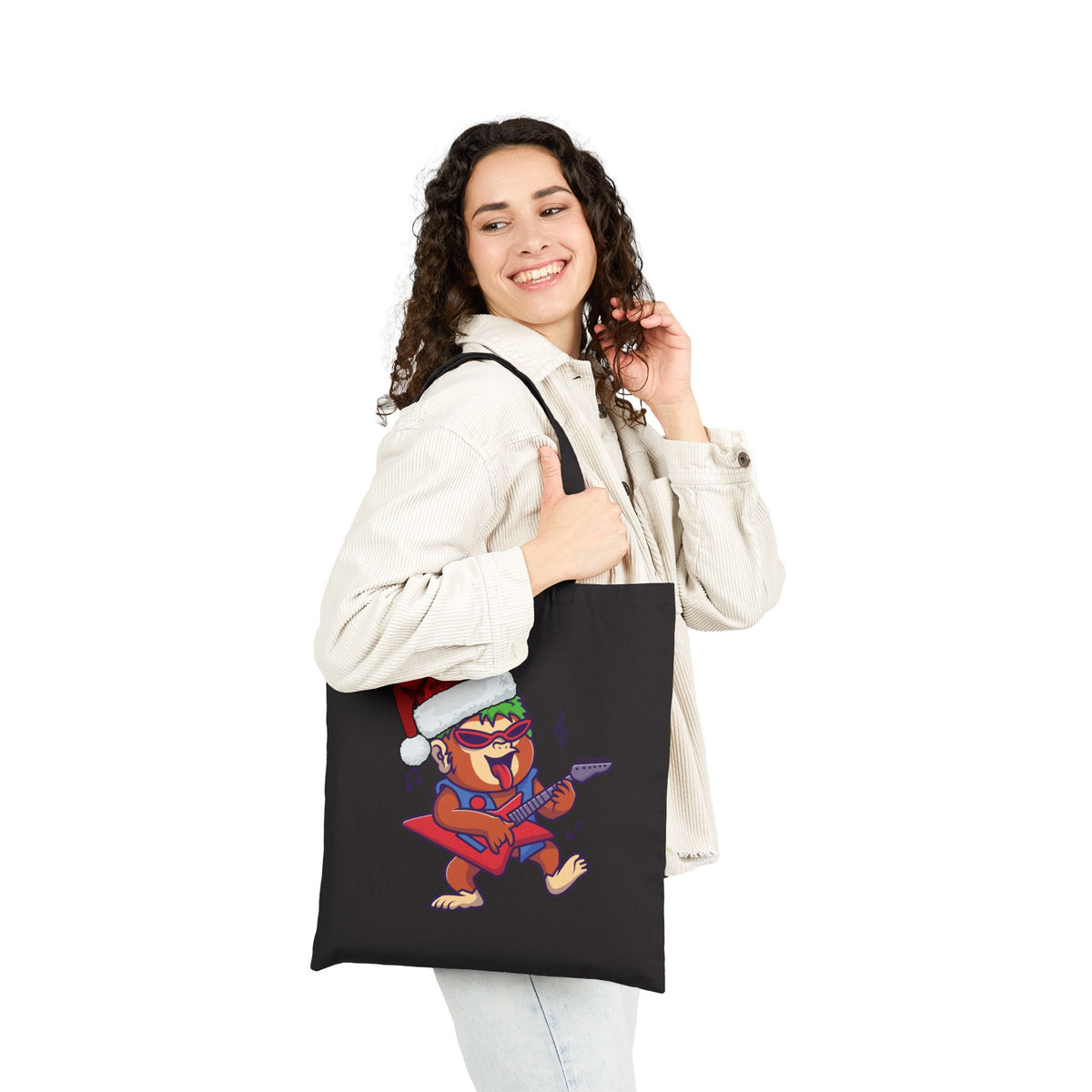 Woman wearing white jacket carrying a black rockstar gorilla christmas tote bag for alternative holiday shopping