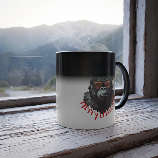 Heat sensitive color changing mug revealing a cool gorilla with sunglasses, a Santa hat, and Merry Christmas text on a rustic wooden windowsill with a mountain view.   
