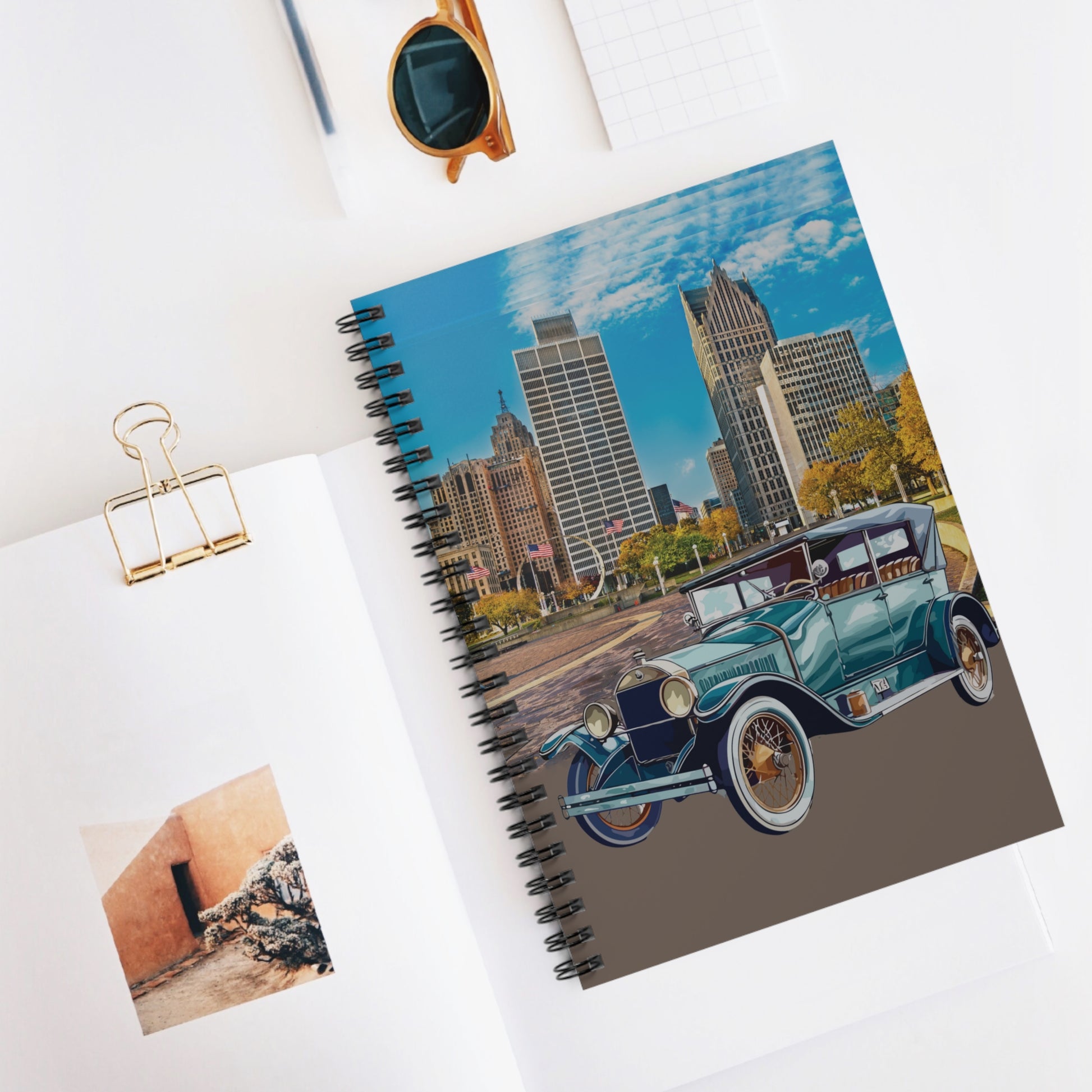 Notebook with a cityscape and vintage Buick car design 