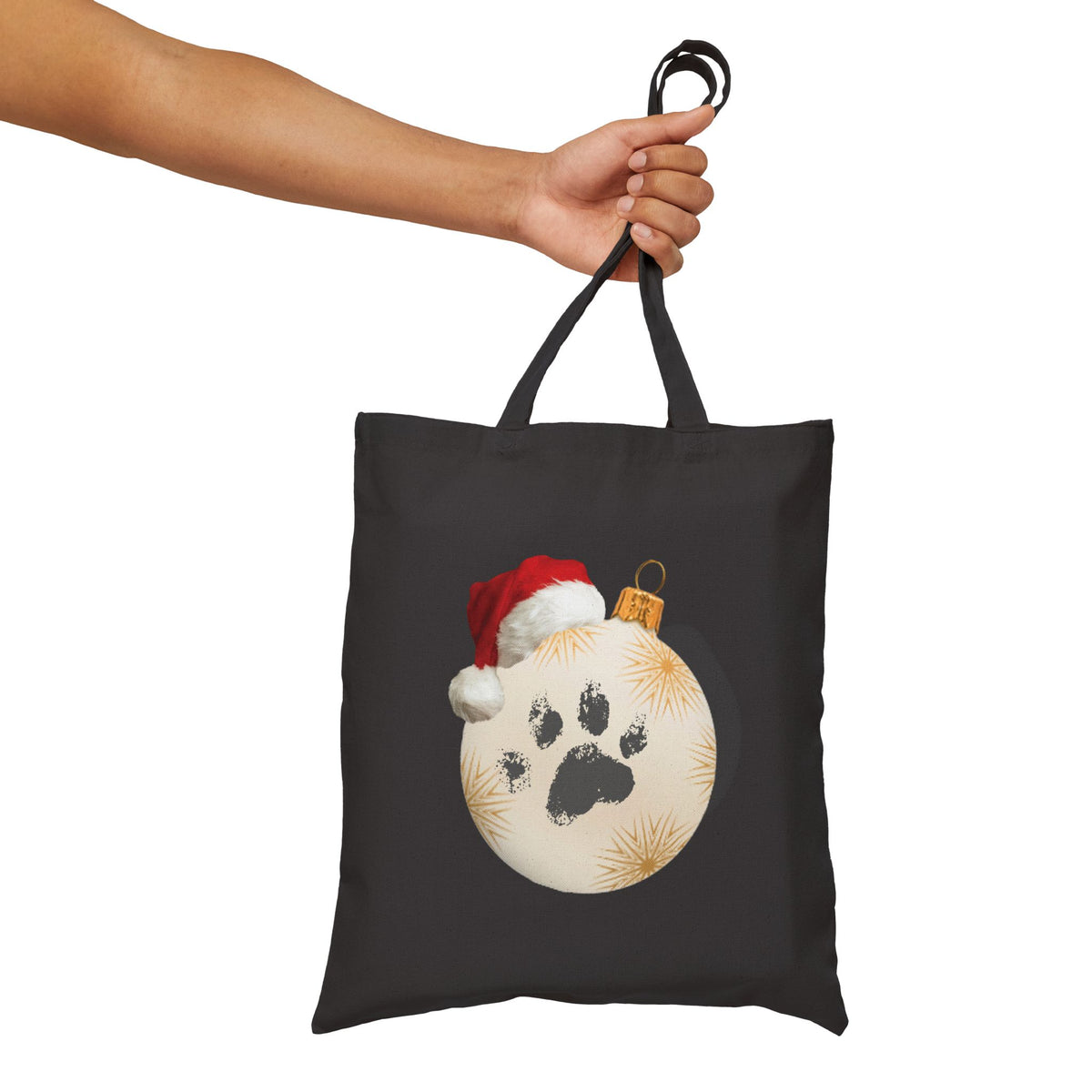 Black canvas tote bag featuring a festive dog paw print christmas ornament illustration for pet lover grocery runs