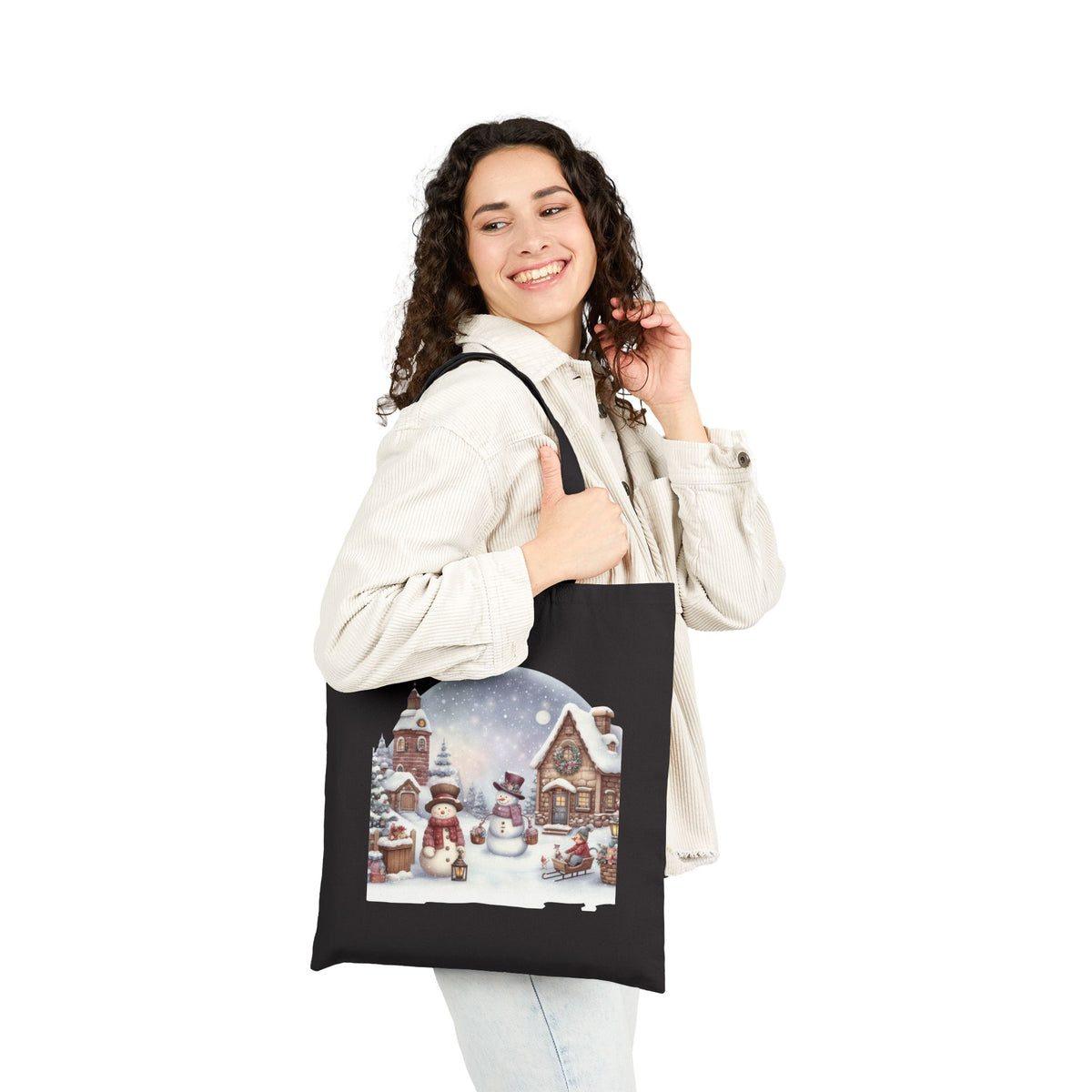 Woman wearing white jacket carrying a black cozy snowman winter village christmas tote bag for holiday gift shopping