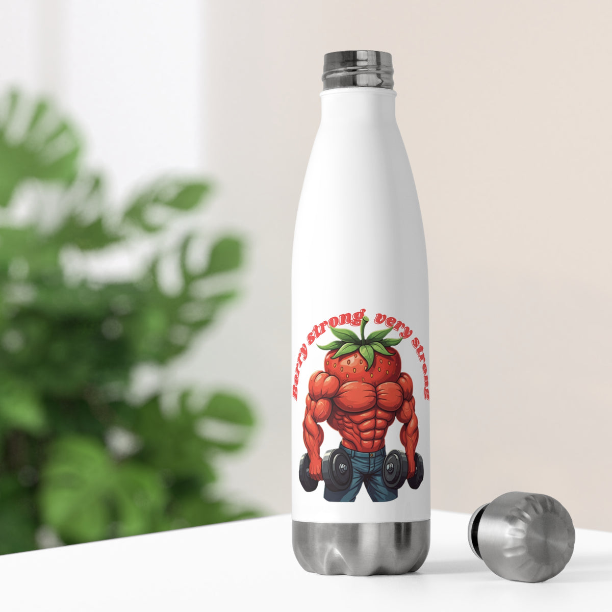 White thermal travel water bottle sitting on a bright desk with its stainless steel cap off, showing a funny muscular strawberry lifting weights.