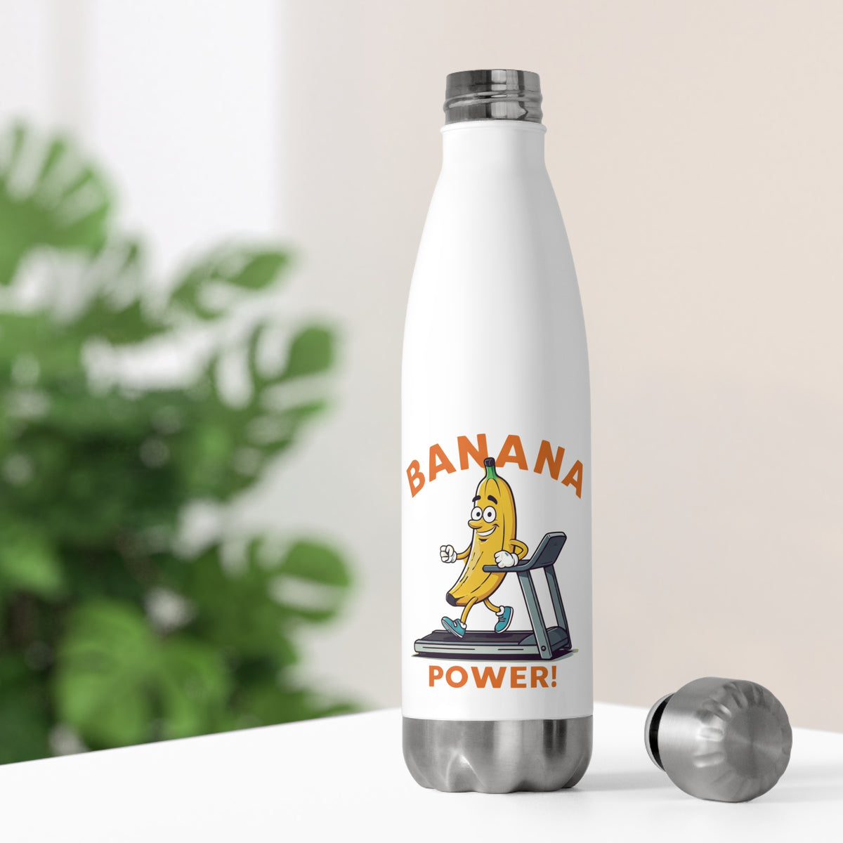 White thermal travel water bottle sitting on a bright desk with its stainless steel cap off, showing a gym banana character running on a treadmill.