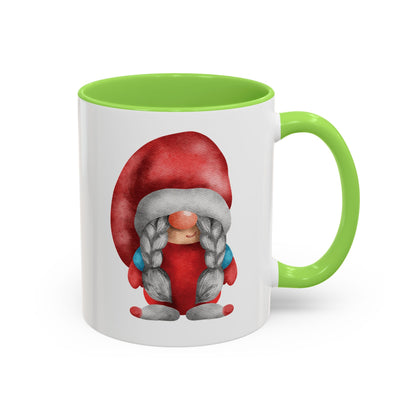 Red gnome light green mug with braids next to a cozy knit sweater and a book)