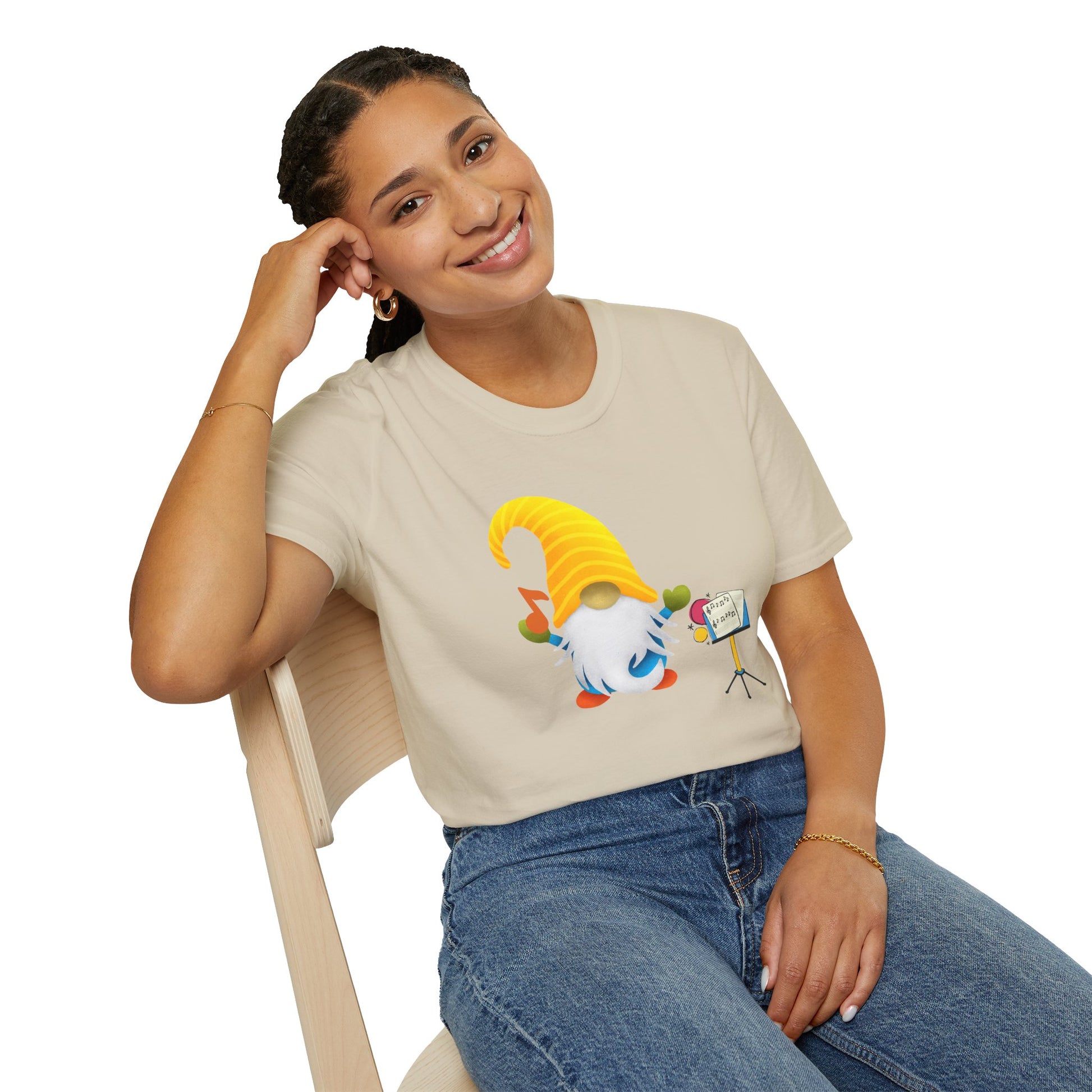 A woman wearing a beige graphic t-shirt with a cartoon gnome behind a music stand-up