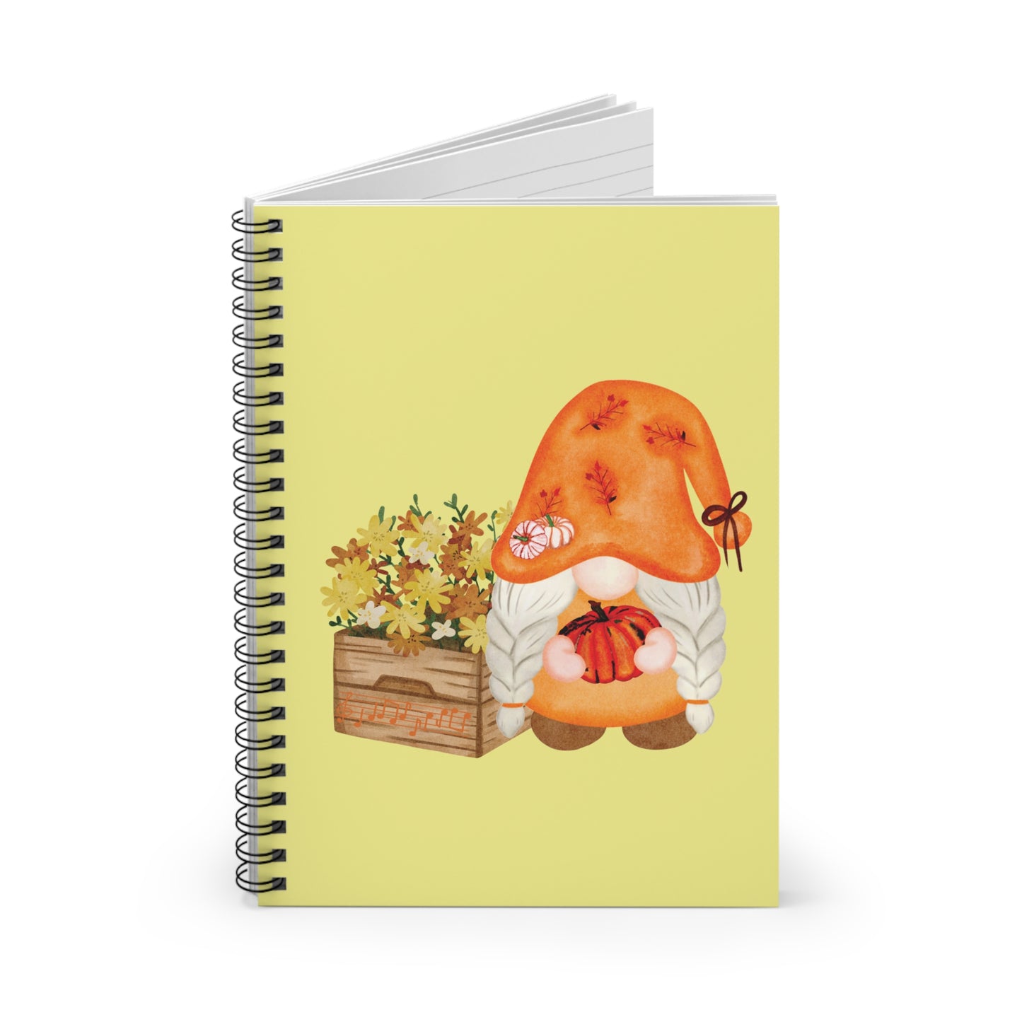 Watercolor illustration of a gray-bearded gnome in an orange leaf-patterned hat holding a small pumpkin, next to a wooden crate of yellow autumn flowers, printed on the cover of a yellow spiral notebook.