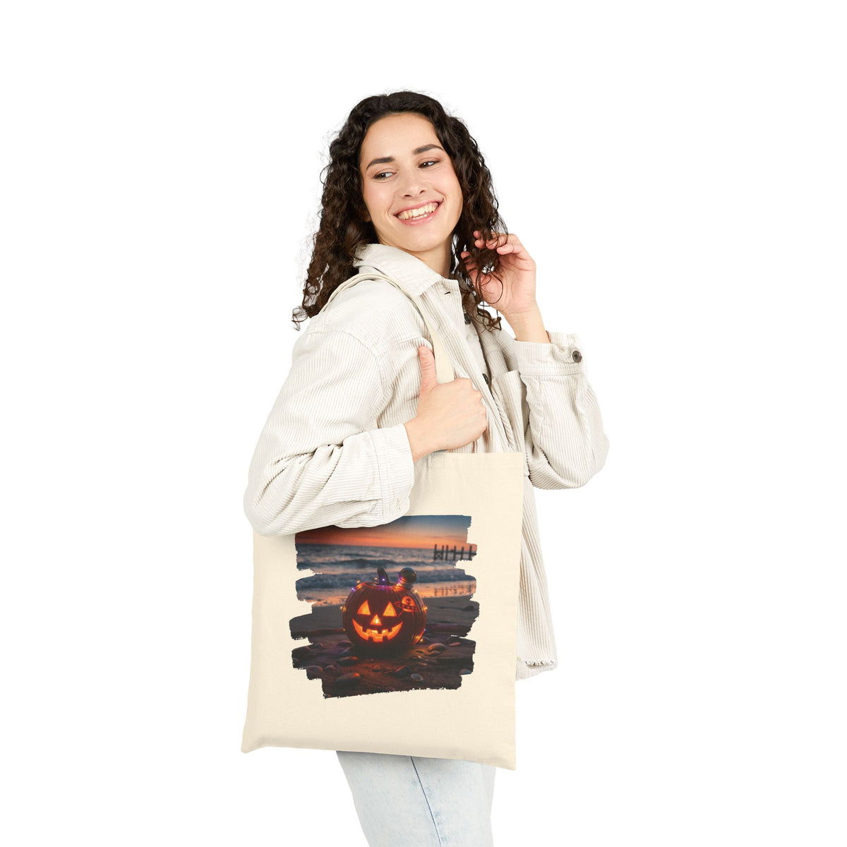 Black canvas tote bag with exclusive Halloween ocean sunset and pumpkin art from From Space Store on a cozy wooden surface.