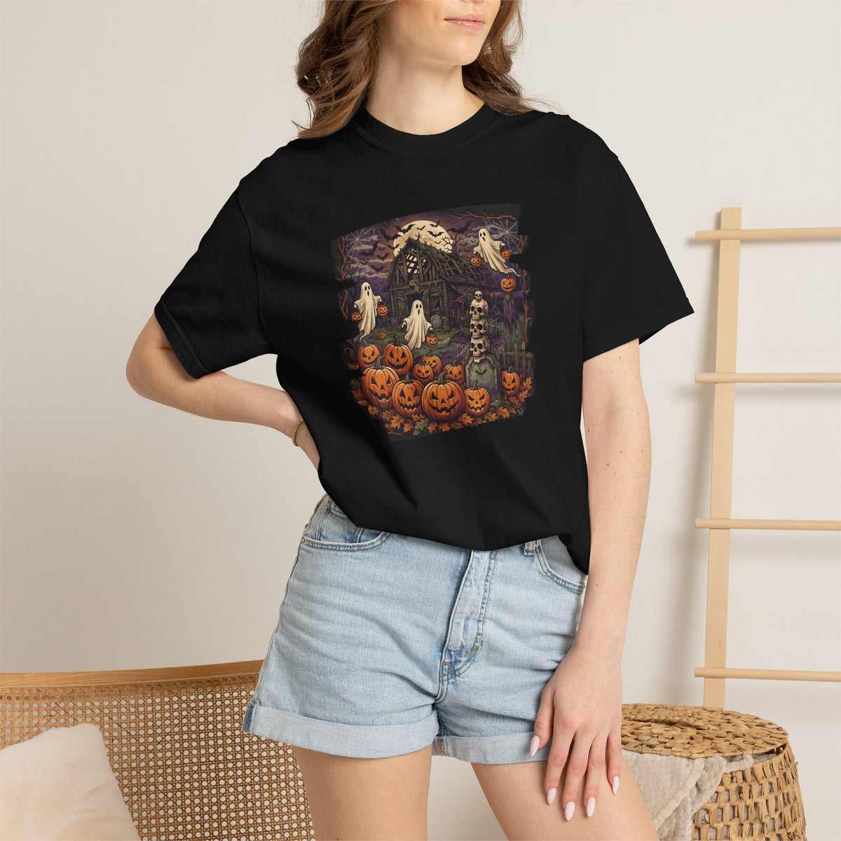 Model wearing the Halloween haunted house graphic t-shirt with denim shorts in a cozy alternative lifestyle setting.