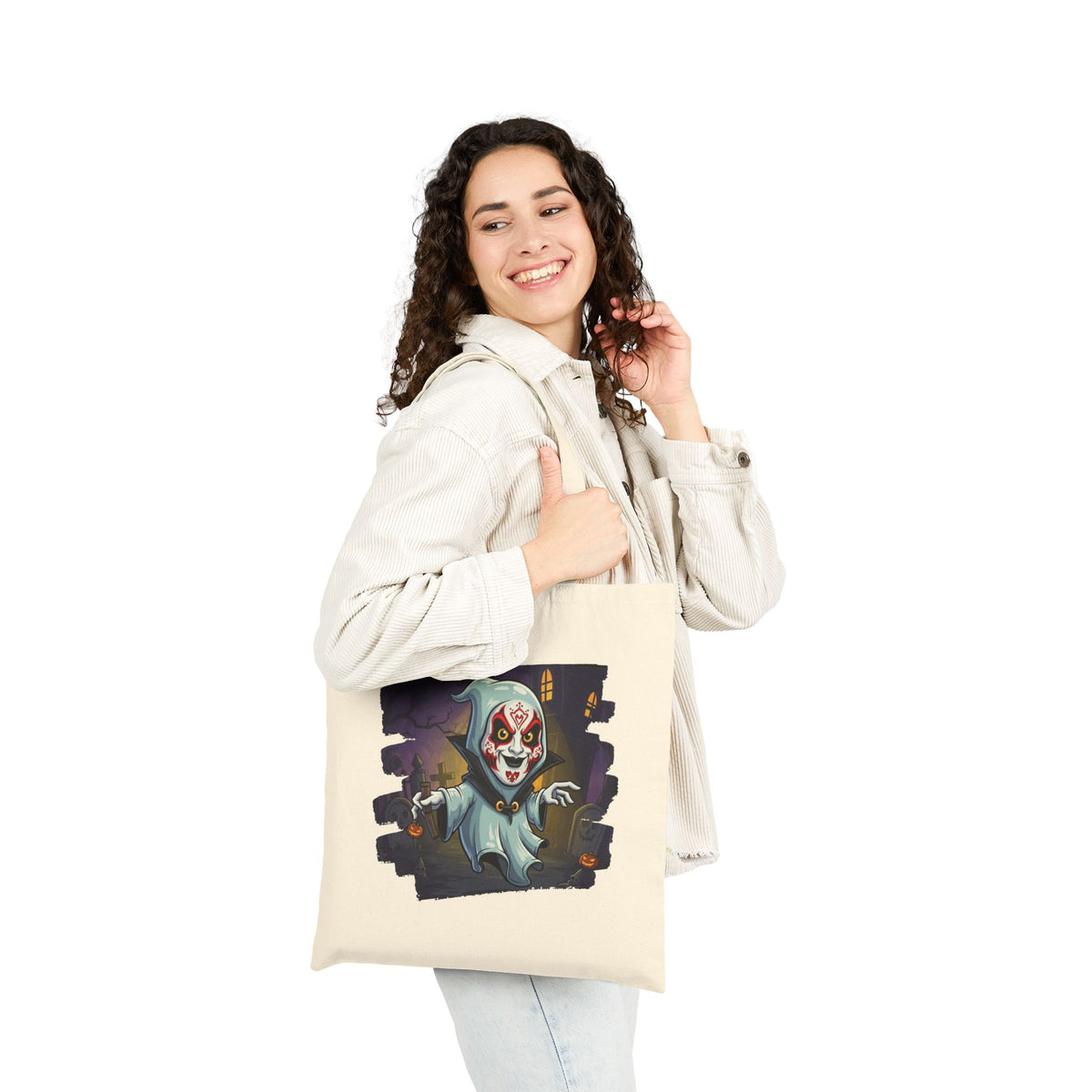 Woman wearing a cream-colored canvas tote bag featuring a spooky Halloween masked ghost graphic.