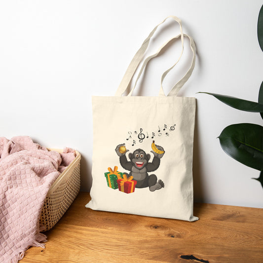 Jingle bells musical monkey canvas tote bag featuring a happy chimp with banana and holiday gifts on natural cotton canvas
