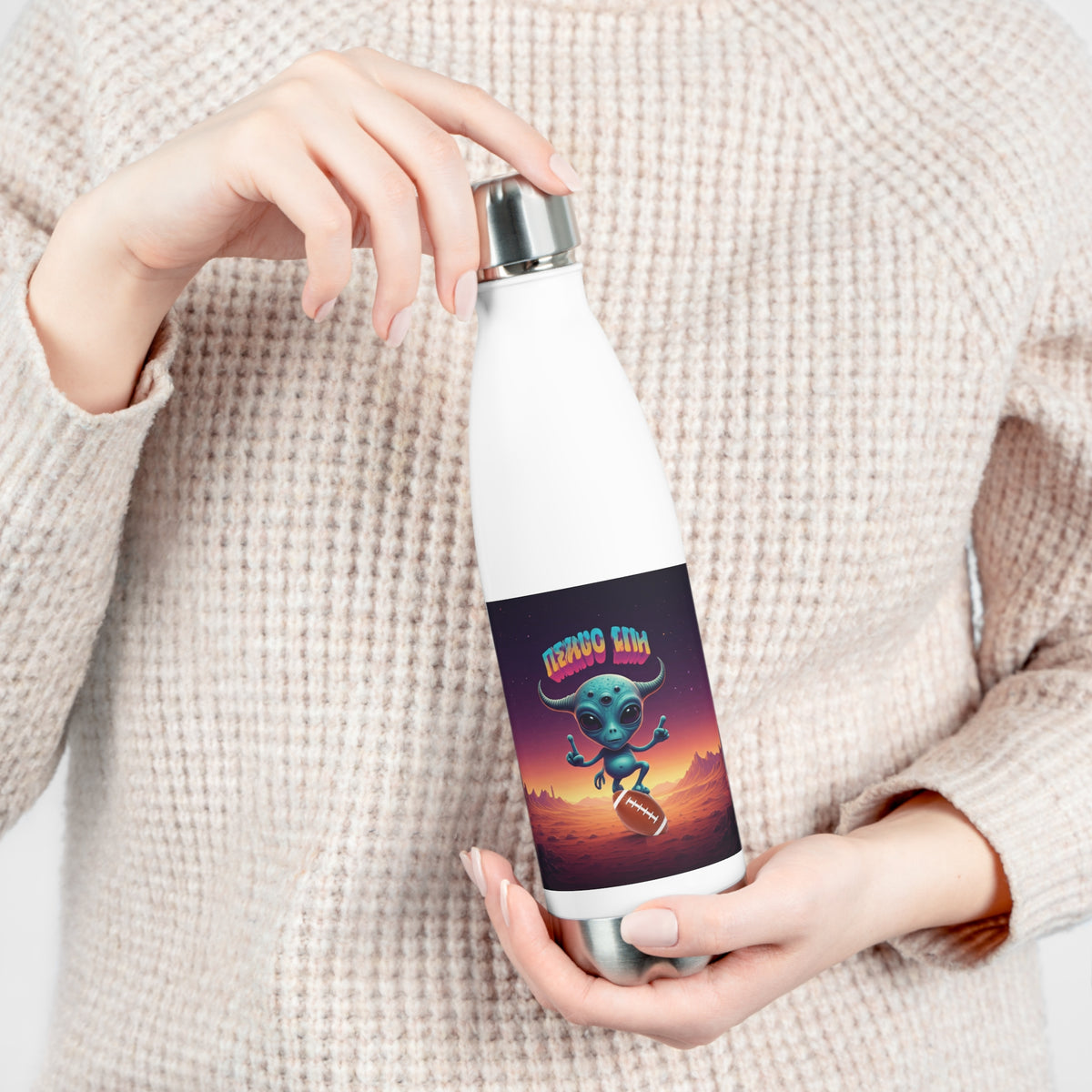 Close-up of hands opening the leak-proof screw cap of a white insulated travel water bottle with sci-fi alien football player artwork.