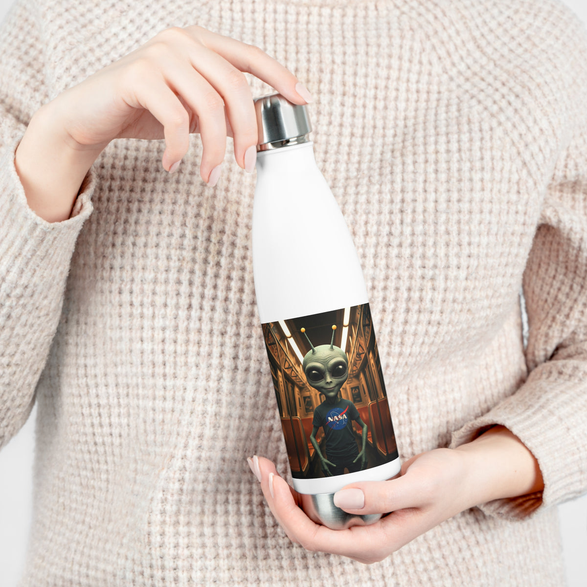 Close-up of hands opening the leak-proof screw cap of a white insulated travel water bottle with sci-fi alien subway artwork.