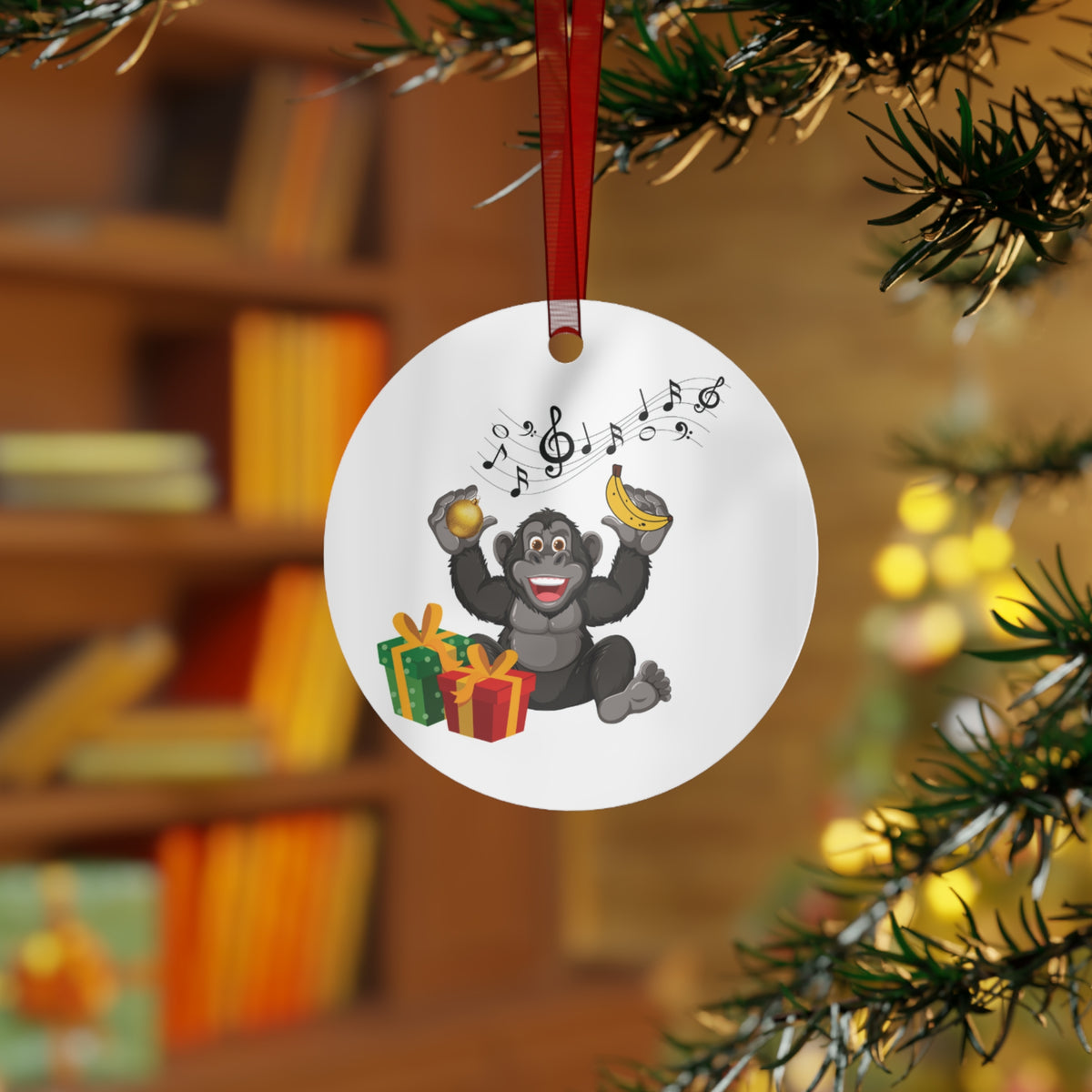 Round ceramic Christmas tree ornament featuring a happy gorilla holding a banana with musical notes and festive gifts hanging on an evergreen branch.