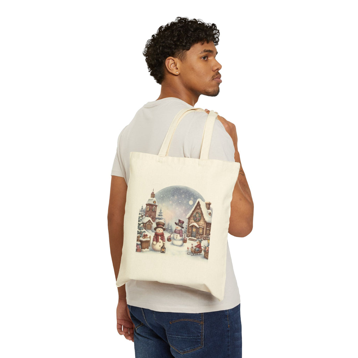Man wearing white t-shirt holding a rustic winter wonderland snowman canvas tote bag for festive christmas errands