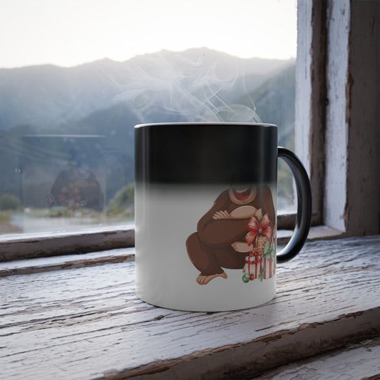 Heat sensitive color changing mug revealing a cute Santa gorilla with christmas gifts on a rustic wooden windowsill with a mountain view.
