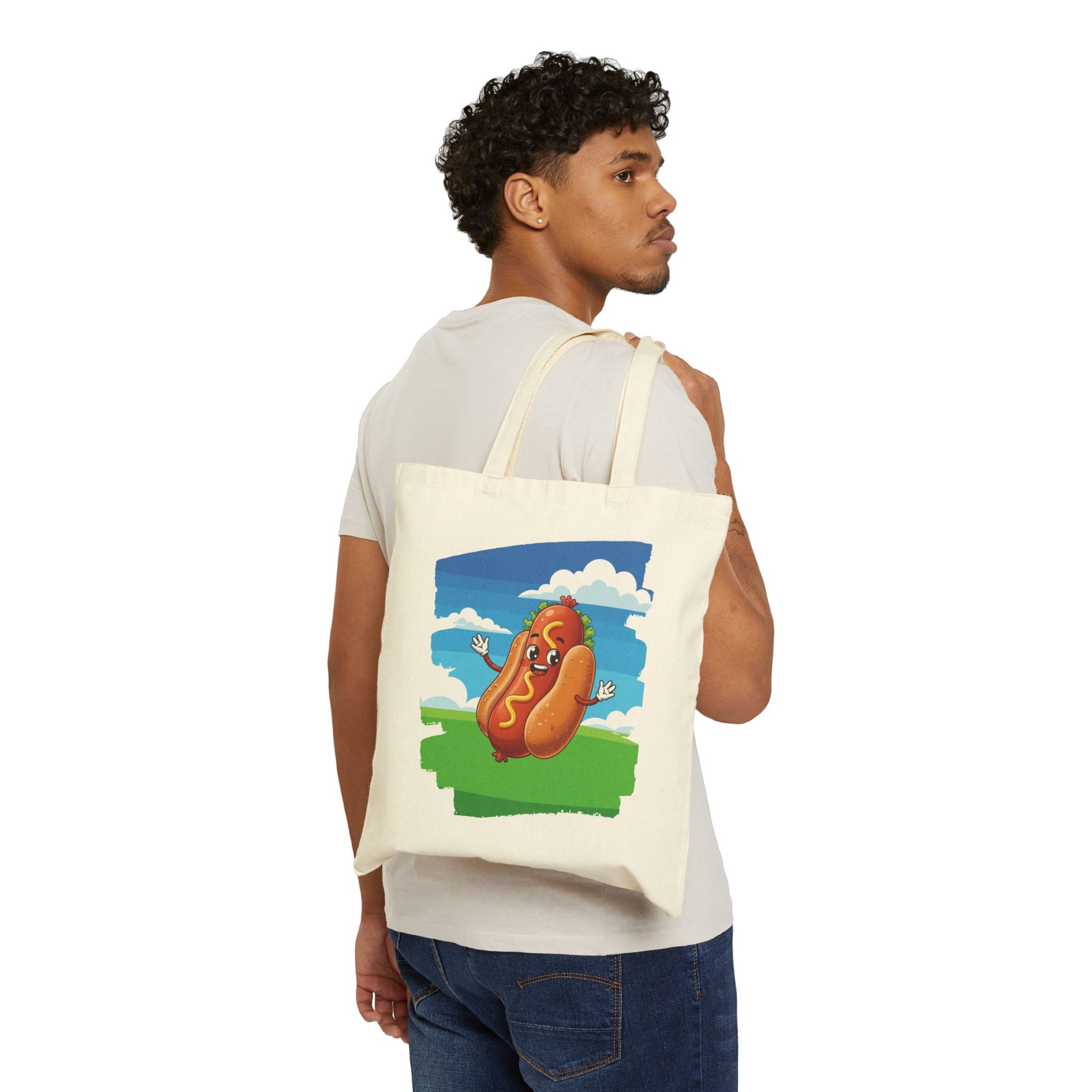 Man holding a tote bag with a cartoon hot dog design on a white background