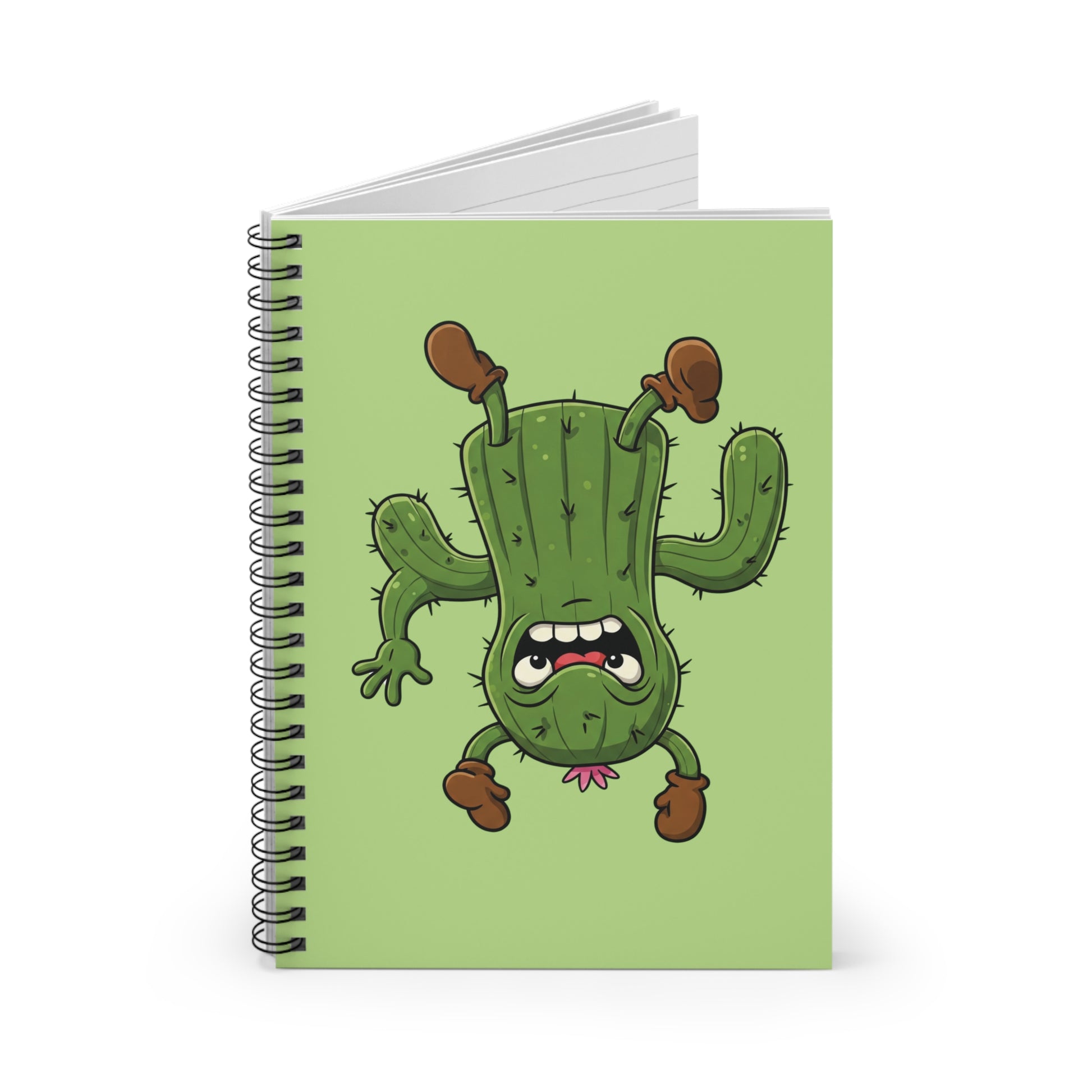 Close-up image of a spiral notebook with a funny cartoon upside-down stressed cactus graphic. Humorous stationery item for stressed students and unique office desk accessory.
