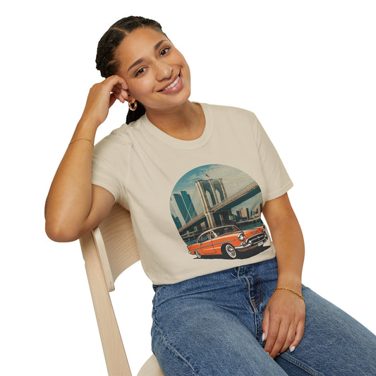 Woman sitting wearing a vintage cars graphic t-shirt featuring a classic vintage car in front of the Brooklyn Bridge
